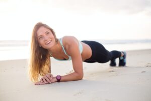 Woman Doing Planks on EBOOST Rescue - Vegan BCAA A beach picture 
